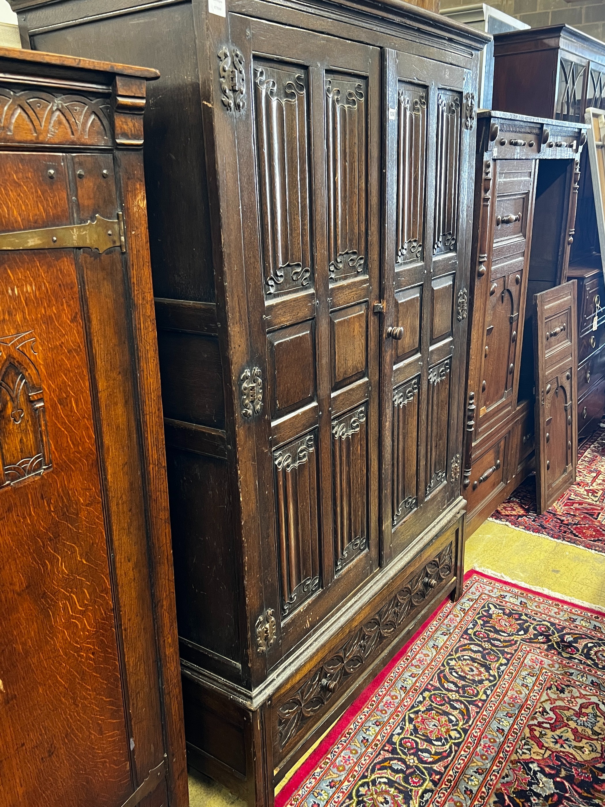 An 18th century style oak linenfold moulded wardrobe, width 123cm, depth 53cm, height 185cm